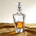 Glass whiskey decanter with a metallic cap on a textured surface