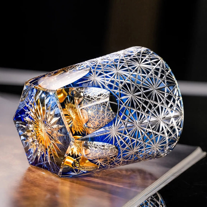 Decorative crystal with geometric patterns and a small figurine inside on a dark background