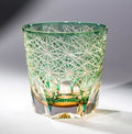 Decorative green glass with geometric patterns on a gray background