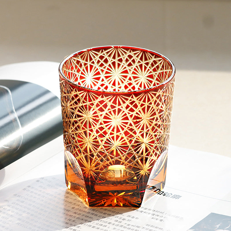 Decorative glass candle holder with geometric pattern on a white surface