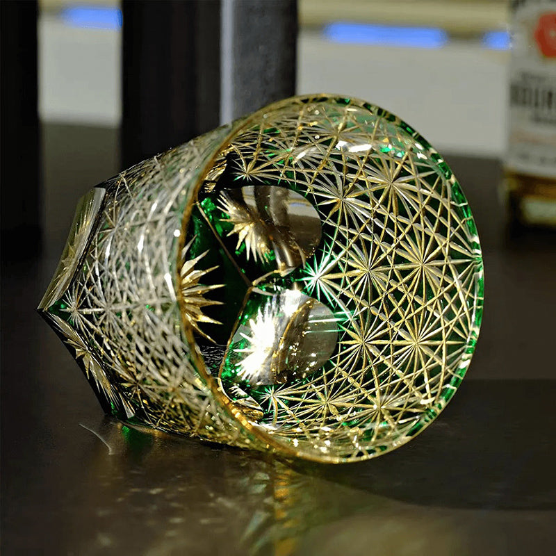 Decorative glass item with gold geometric patterns on a reflective surface