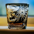 Decorative glass with engraved dragon design on a blurred background
