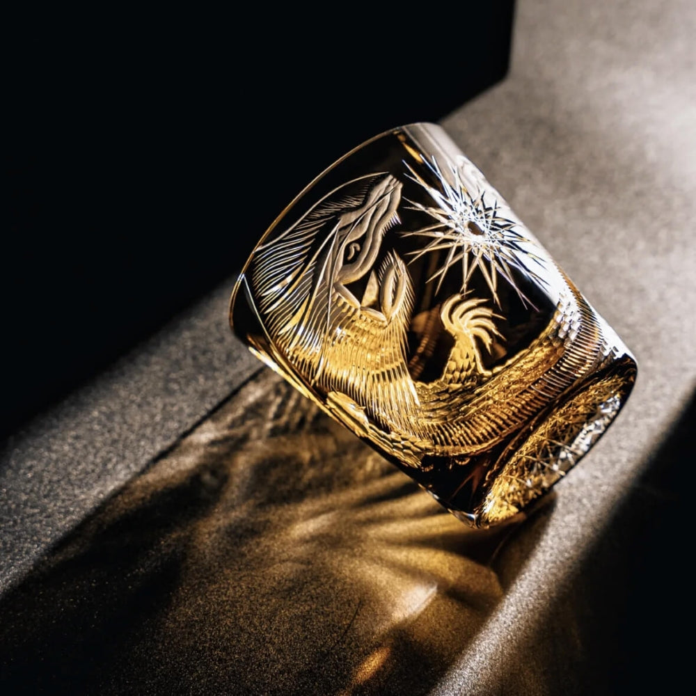 Gold ring with intricate design on a dark surface