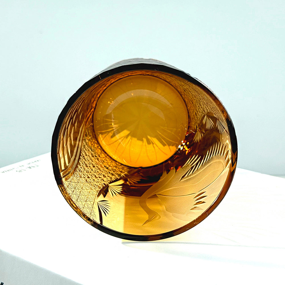 Amber glass bowl with intricate patterns on a light blue background