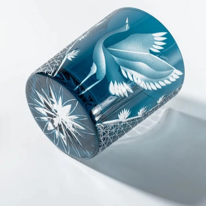 Decorative cylindrical container with floral patterns on a light gray background