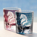 Two glass tumblers with horse designs on a blurred background