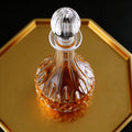 Glass decanter with a metal stopper on a gold tray