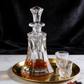 Crystal decanter with liquid on a gold tray with two glasses 